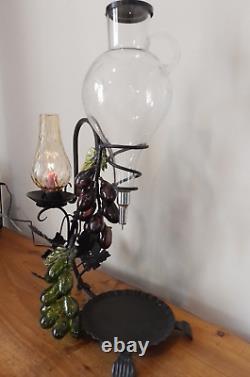 Vintage decorative wrought iron wine dispenser with glass candle vase