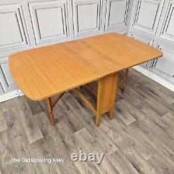 Table de salle à manger en bois de teck avec rabats rétractables style rétro vintage du milieu du XXe siècle.