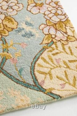 Tapis en laine tufté à motifs floraux en sauge et crème, style vintage, décoration traditionnelle.