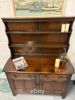 Une commode vintage ERCOL Old Colonial avec deux tiroirs, des placards et un porte-assiettes pour la cuisine.